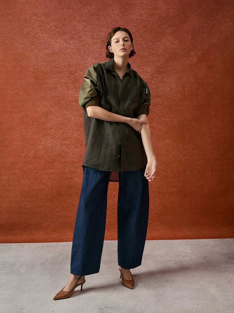  Pointed-toe pumps add a touch of polish to a relaxed outfit featuring baggy jeans and a loose tailored blouse.