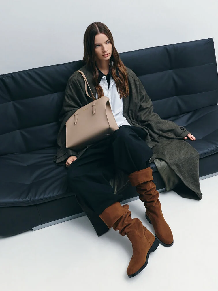 A button-up shirt and trousers co-ordinate styled with knee-high boots and a trench coat, ideal for days on campus.