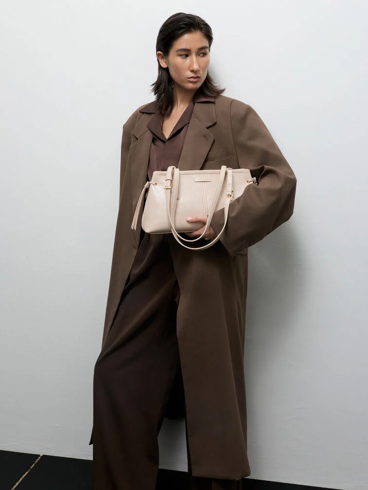 Oat elongated-handle shoulder bag offers a striking contrast to fall’s dark outfits