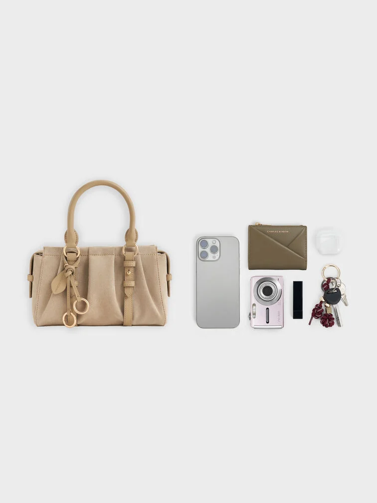 Beige top handle bag with a crossbody option, practical for the outdoor portions of fall weddings.