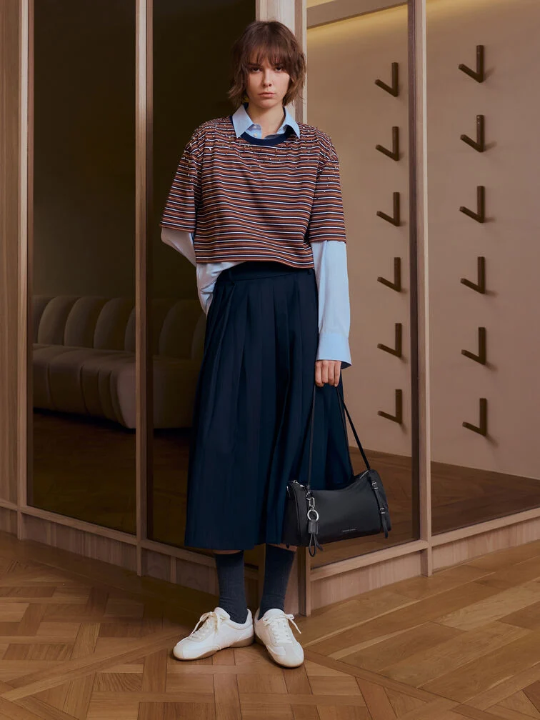 Layered striped T-shirt and light blue blouse paired with a navy maxi skirt, white sneakers, and a black nylon shoulder bag.