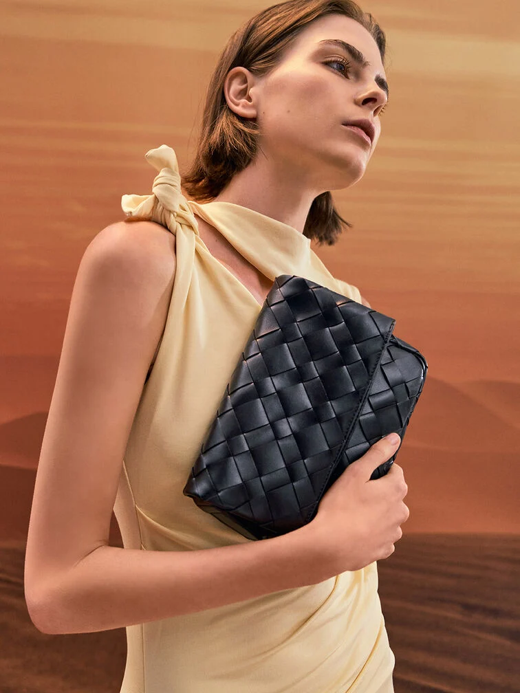 A butter yellow dress styled with a black woven clutch for a classic spring wedding guest look. 