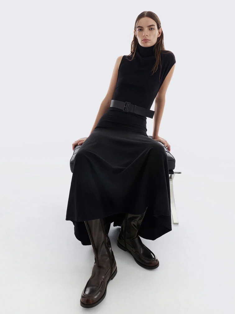 Dark brown knee-high loafer boots paired with a black turtleneck midi dress. 