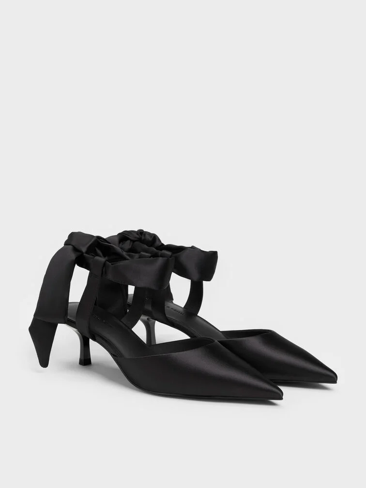 Black satin tie-around kitten heels offer a comfortable fit with a refined aesthetic. 