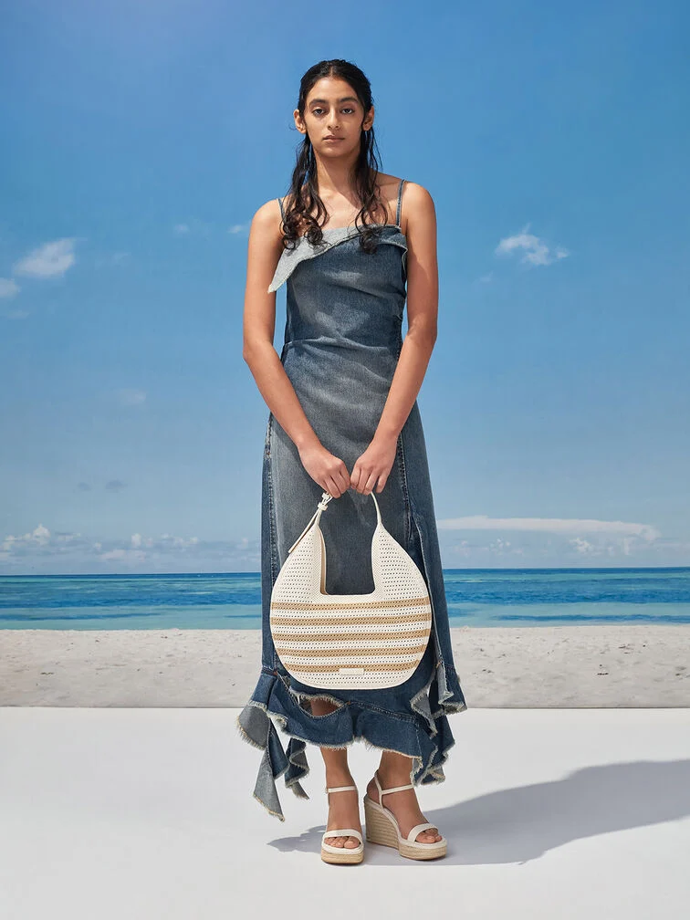 Accessorise a distressed denim dress with a woven bag and espadrilles in light neutral tones for visual contrast and textural interest.  