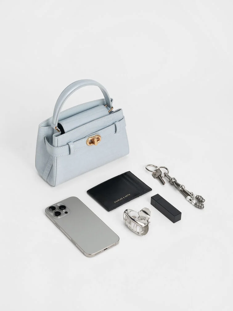 Light blue croc-effect top-handle bag, a standout choice for evening soirées.